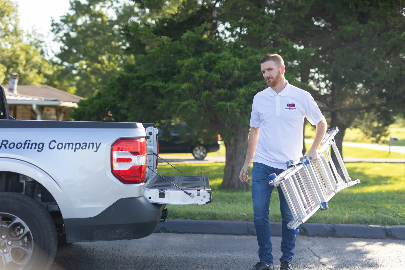 SRA roofing technician carrying a ladder from a company truck