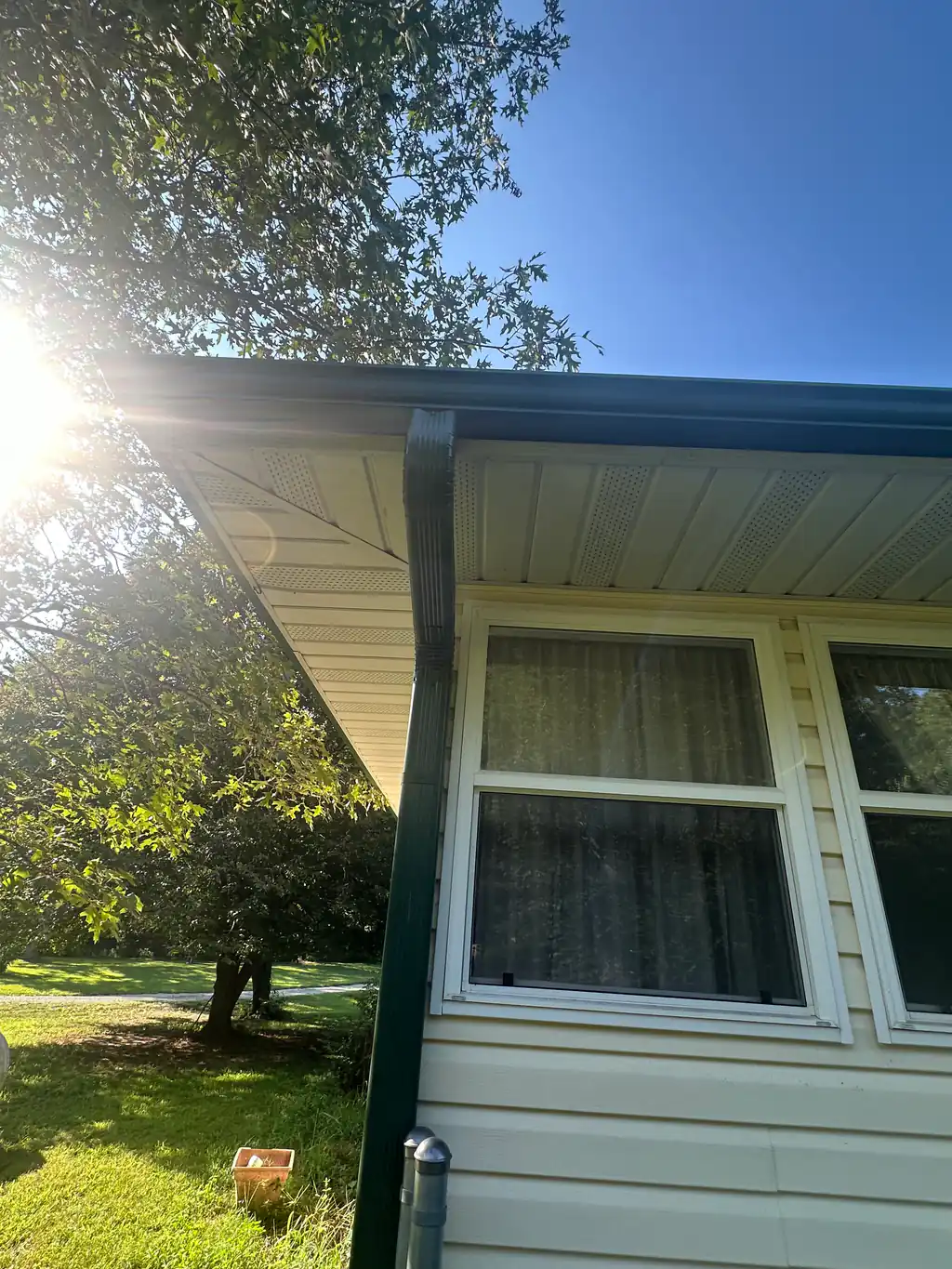 Gutter and downspout connection at a residential roof edge